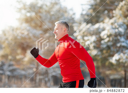 Athletic senior man in sportswear running at winter park, side view. Seasonal sports and tempering concept Athletic senior man in sportswear running at winter park, side view. Seasonal sports and tempering concept 84882872