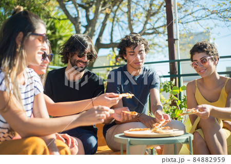 Peaceful male and female friends sitting at table at party Peaceful male and female friends sitting at table at party 84882959