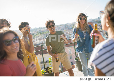 Active friends at terrace roof party on sunny day 84883121