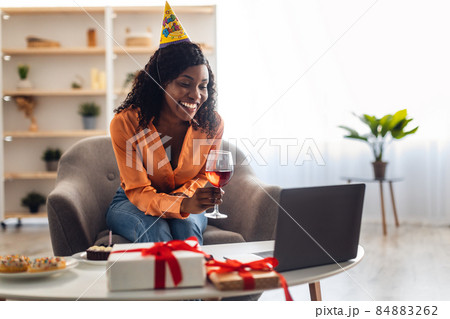 Black Lady Toasting To Laptop Celebrating Birthday Video Calling Indoor Black Lady Toasting To Laptop Celebrating Birthday Video Calling Indoor 84883262