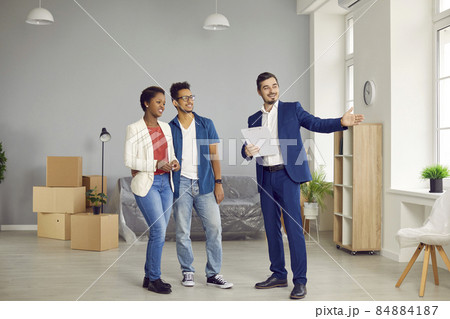 A couple of African-Americans husband and wife came to inspect the house for purchase. A young couple in love buys real estate. A real estate agent shows a house to an African-American couple. 84884187