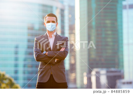 Businessman looking on copy space while standing against glass skyscraper 84885859
