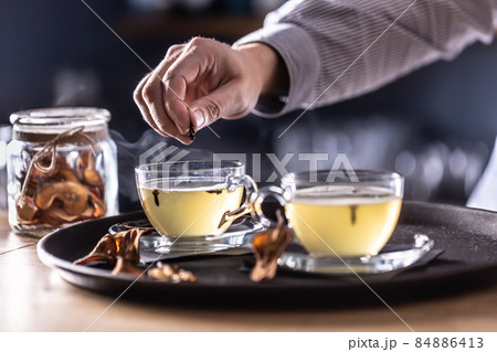 Detail of a bartender's hand flavoring Hot Teddy whiskey drink with cloves 84886413