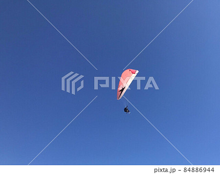 Skydiver is flying with parachute in blue sky 84886944