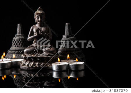 Statue of Buddha sitting in meditation, .candles, With black copy space . Zen and meditation concept. Statue of Buddha sitting in meditation, .candles, With black copy space . Zen and meditation concept. 84887070