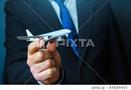 The official holds the plane in his hand. Organization of flight traffic. Business and transport, air communication. Infrastructure for business development. Airline loyalty program. Tourism travel. 84889405