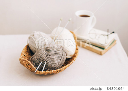 Natural wool in balls of various pastel colors in a wicker basket. Knitting threads close-up on a light background. Natural wool in balls of various pastel colors in a wicker basket. Knitting threads close-up on a light background. 84891064
