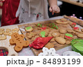 Happy Asian little girl cooking gingerbread at home with parent for Christmas day. Homemade Xmas cookies for kid. 84893199