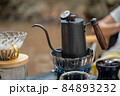 Man dripping hot coffee and camping near river at nature park. Outdoor activity and relax on holiday. 84893232
