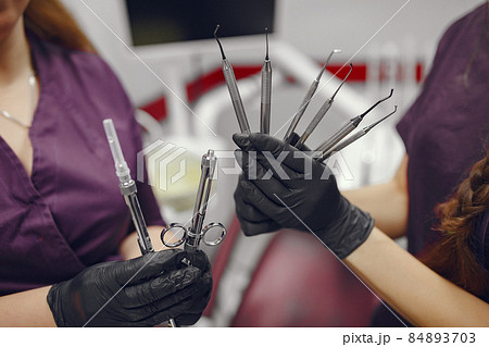 Dental tools in a dentist hand 84893703