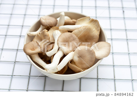 Fresh oyster mushroom in white bowl on white background. Fresh oyster mushroom in white bowl on white background. 84894162