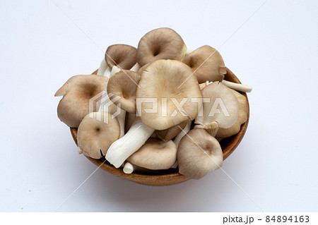 Fresh oyster mushroom in wooden bowl in bowl on white background. 84894163