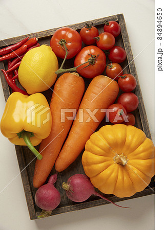 vegetable concept various colorful vegetables being put on a cutting wooden board over many green vegetables vegetable concept various colorful vegetables being put on a cutting wooden board over many green vegetables 84894650