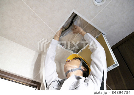 天井点検口から天井裏を点検する作業員 イメージの写真素材