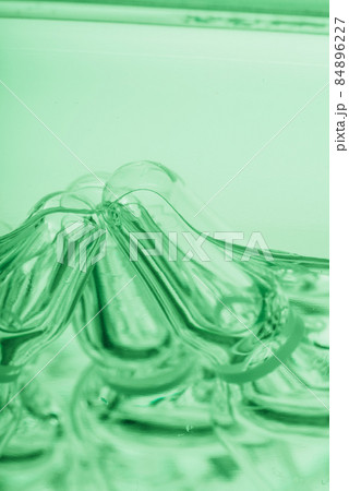 Glass medical ampoule vial for injection. Medicine is liquid sodium chloride with of aqueous solution in ampulla. Close up. Bottles ampule multicolor. Glass medical ampoule vial for injection. Medicine is liquid sodium chloride with of aqueous solution in ampulla. Close up. Bottles ampule multicolor. 84896227