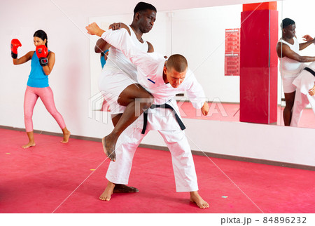 Two men exrcising self defence moves and woman boxing Two men exrcising self defence moves and woman boxing 84896232