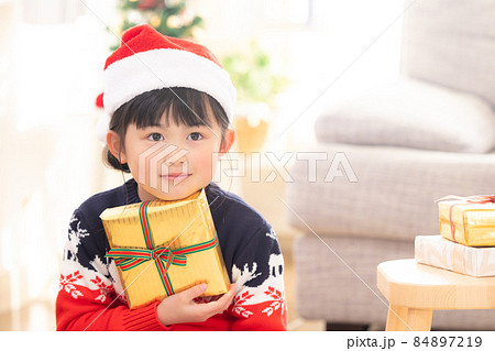 クリスマスプレゼント貰って微笑む女の子 84897219