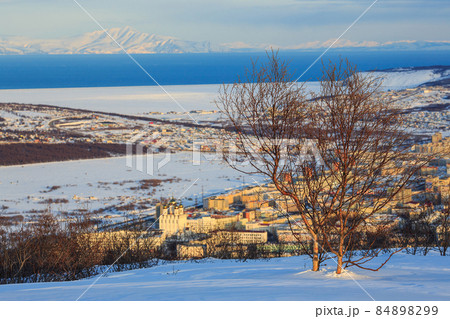 Winter landscape. View from the mountains to the northern city and sea bay. Winter landscape. View from the mountains to the northern city and sea bay. 84898299