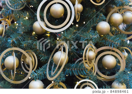The Christmas tree is decorated with stylish golden balls. Trend direction in monochrome design. Stylish Christmas tree. The Christmas tree is decorated with stylish golden balls. Trend direction in monochrome design. Stylish Christmas tree. 84898461