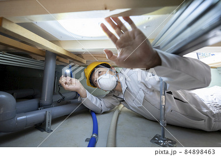 住宅の床下を点検する作業服の男性 84898463