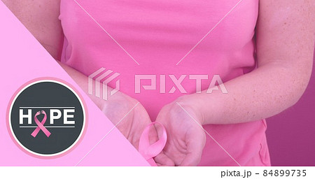 Composite image of woman with breast cancer awareness ribbon and hope text 84899735