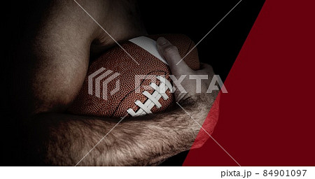 Midsection of shirtless muscular male american football athlete holding ball with copy space Midsection of shirtless muscular male american football athlete holding ball with copy space 84901097