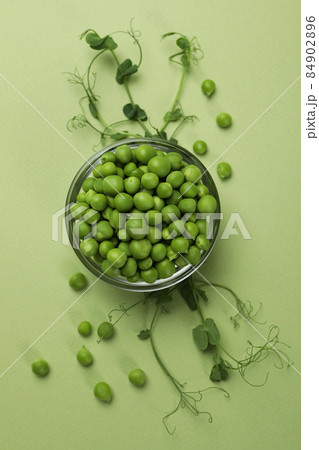 Bowl with pea seeds on green background Bowl with pea seeds on green background 84902896