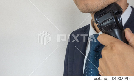 電気シェーバーでヒゲを剃るビジネスマン 84902995
