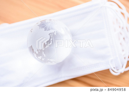 積み重ねた白いサージカルマスクの上の地球儀　新型コロナウイルス感染予防　マスクで得る安心安全 84904958