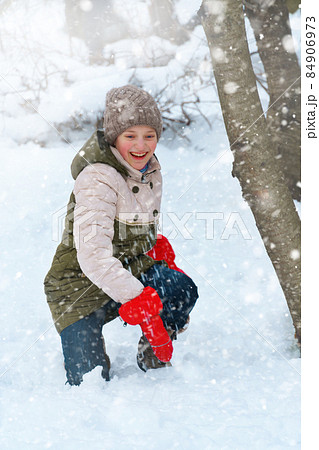 a girl plays snowballs outside, beautiful winter weather and white snow around 84906973