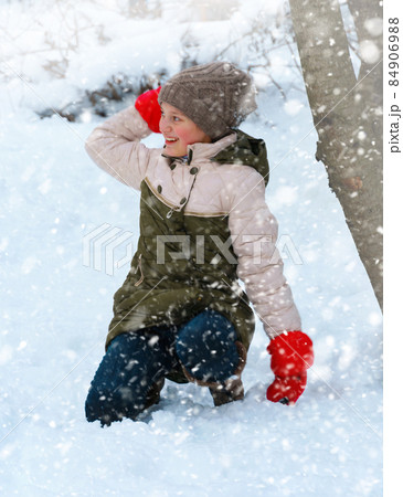 a girl plays snowballs outside, beautiful winter weather and white snow around a girl plays snowballs outside, beautiful winter weather and white snow around 84906988