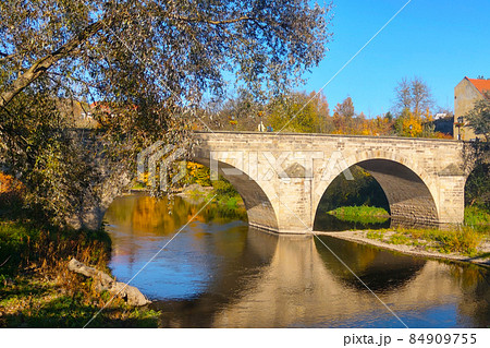 Beautiful old bridge over the river on a sunny day. 84909755