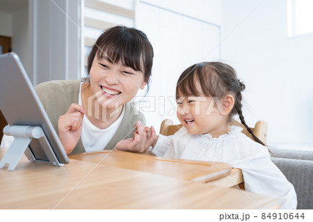 自宅のダイニングでママと一緒にタブレットを見る2歳の女の子 自宅のダイニングでママと一緒にタブレットを見る2歳の女の子 84910644