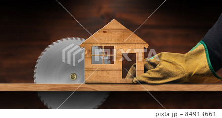 Metal Circular Saw Blade in Motion and Small Wooden Model House 84913661