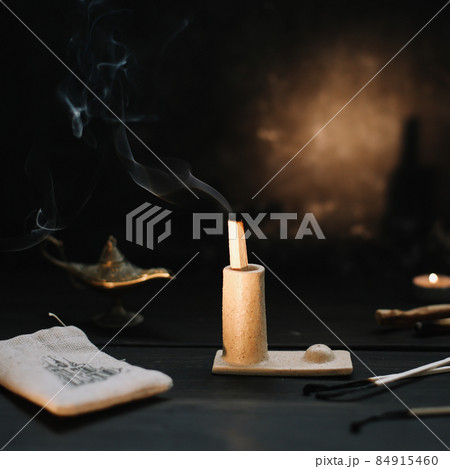 Palo Santo stick on fire with smoke in a beautiful candlestick. Cozy evening at home. Palo Santo stick on fire with smoke in a beautiful candlestick. Cozy evening at home. 84915460