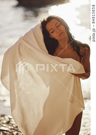 Adorable Beach Woman in the Towel Drying after Swimming on the Deserted Beach During Summer Vacation Outdoors 84915658