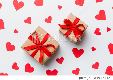 Valentine day composition Background: red gift box with bow and heart. Christmas present. View from above. Holday greeting card Valentine day composition Background: red gift box with bow and heart. Christmas present. View from above. Holday greeting card 84917142