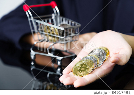 Bitcoin coins in the hand of a business women 84917492