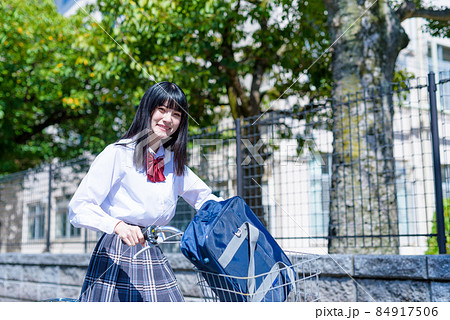 笑顔で自転車通学する女子高校生　住宅地　市街地　カメラ目線　朝カラー 84917506