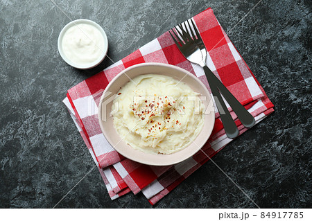 Concept of tasty eating with mashed potatoes on black smokey table Concept of tasty eating with mashed potatoes on black smokey table 84917785