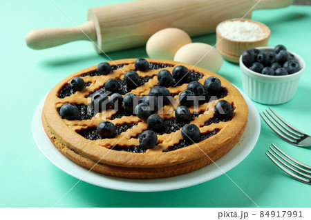 Concept of cooking blueberry pie on mint background Concept of cooking blueberry pie on mint background 84917991