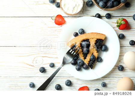 Concept of delicious dessert with blueberry pie on white wooden table Concept of delicious dessert with blueberry pie on white wooden table 84918026