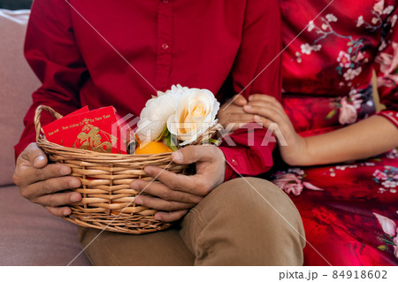 Hands of young couple with basket containing flowers and postcard Hands of young couple with basket containing flowers and postcard 84918602