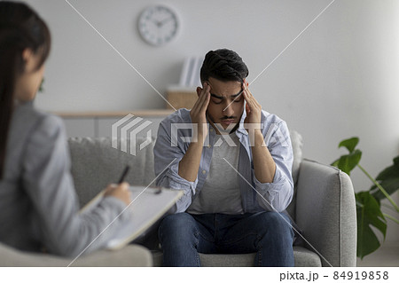 Desperate arab guy suffering from nevrous breakdown or depression, having session at psychologist's office Desperate arab guy suffering from nevrous breakdown or depression, having session at psychologist's office 84919858