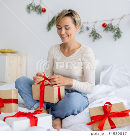 Happy lady celebrating Christmas wrapping gift box Happy lady celebrating Christmas wrapping gift box 84920017