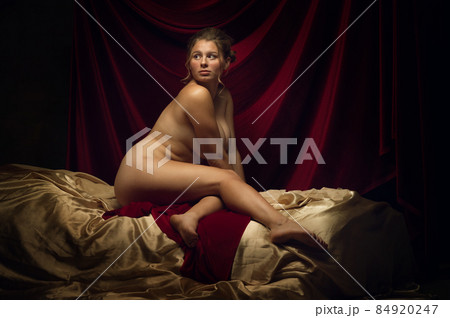 Vintage portrait of young medieval beautiful girl posing like artist's model on dark background. Renaissance style concept 84920247