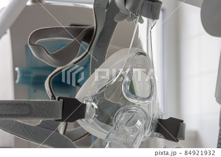 Non-invasive ventilation face mask, on background medical ventilator in ICU in hospital. 84921932
