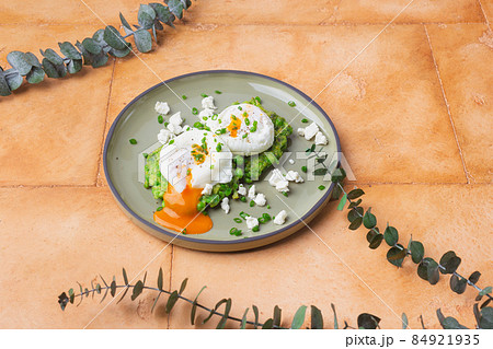 Green peas with poached eggs on sand color background 84921935
