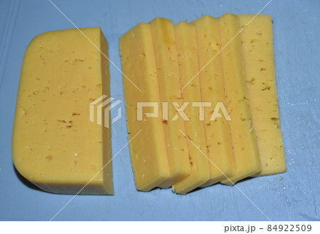 Pieces of juicy cheese cut on a cutting board Pieces of juicy cheese cut on a cutting board 84922509