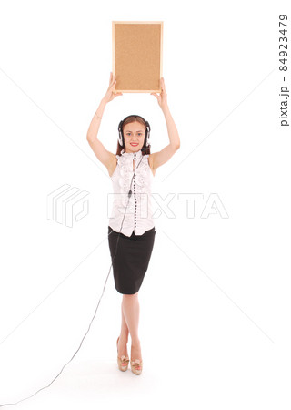 Teenage girl in headphones, holding cork board. 84923479